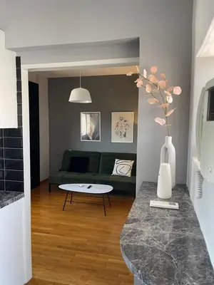 a living room with a green couch and a table at Exarcheia Athens Penthouse in Athens