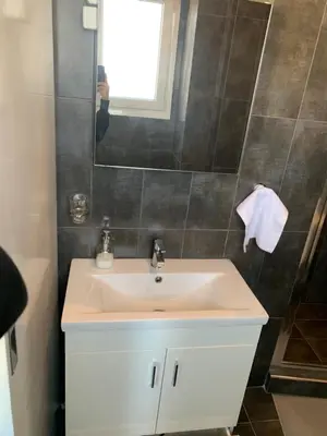 a bathroom with a white sink and a window at Exarcheia Athens Penthouse in Athens