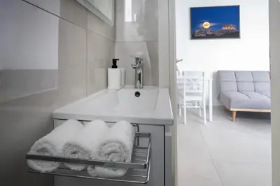a bathroom with a sink and white towels at White & Stars in Athens