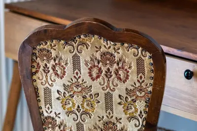 a wooden chair with an embroidery on the back at White & Stars in Athens