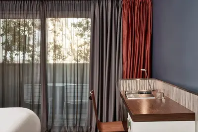 a bedroom with a bed and a sink and a window at AthensWas Design Hotel in Athens