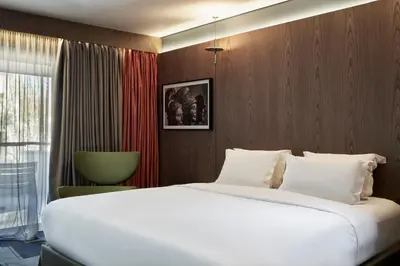 a bedroom with a large white bed and a window at AthensWas Design Hotel in Athens