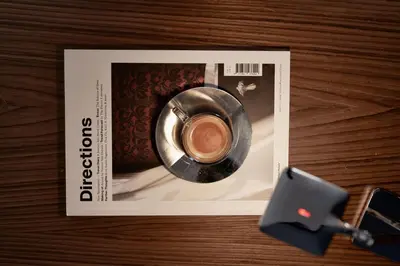 a magazine with a cup of coffee on a table at AthensWas Design Hotel in Athens
