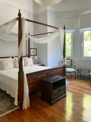 a bedroom with a canopy bed and a chair at Athens Center, Akadimias 77 - 1rst floor in Athens