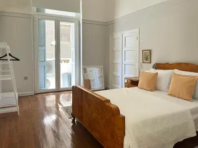 a bedroom with a large bed with white sheets and wooden floors at Athens Center, Akadimias 77 - 1rst floor in Athens