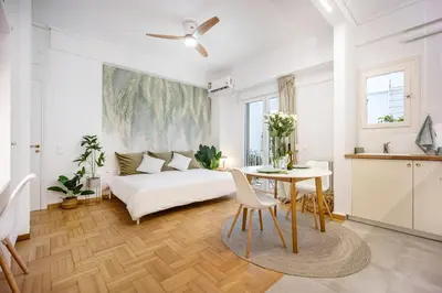 a white living room with a bed and a table at Palm Athens by GK Properties in Athens