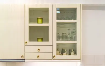 a white cabinet filled with glasses and vases at Palm Athens by GK Properties in Athens