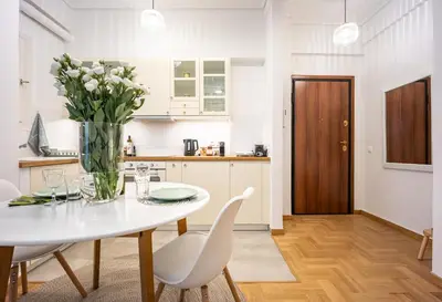 a kitchen and dining room with a white table and chairs at Palm Athens by GK Properties in Athens