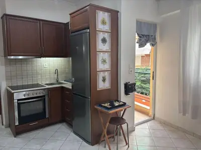 a kitchen with a stainless steel refrigerator and a table at Thissio Gazi apartment with private parking in Athens