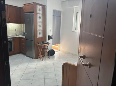 a kitchen with a refrigerator and a tile floor at Thissio Gazi apartment with private parking in Athens