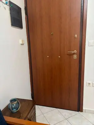 a wooden door in a room with a wooden table at Thissio Gazi apartment with private parking in Athens
