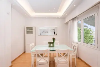 a dining room with a white table and chairs at Modern spacious apt in Athens in Athens
