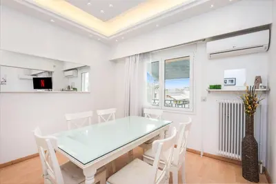 a dining room with a glass table and white chairs at Modern spacious apt in Athens in Athens
