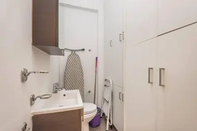 a white bathroom with a sink and a toilet at Modern spacious apt in Athens in Athens