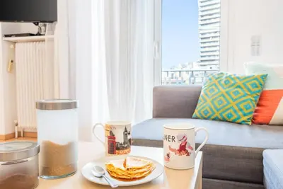 a coffee table with two mugs and a plate of pancakes at Modern spacious apt in Athens in Athens