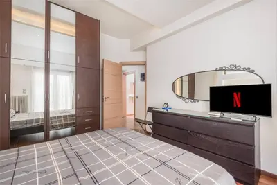 a bedroom with a large bed and a television at Modern spacious apt in Athens in Athens
