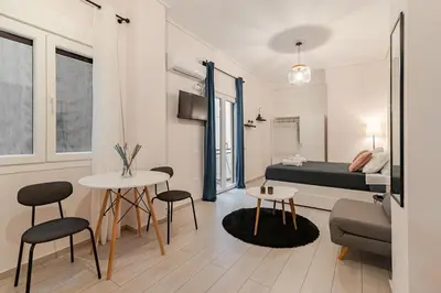 a living room with a bed and a table and chairs at Alice Museum Retreat in Athens
