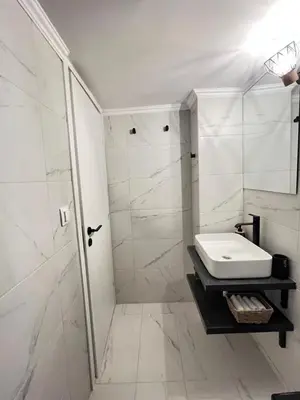 a white bathroom with a sink and a shower at Alice Museum Retreat in Athens