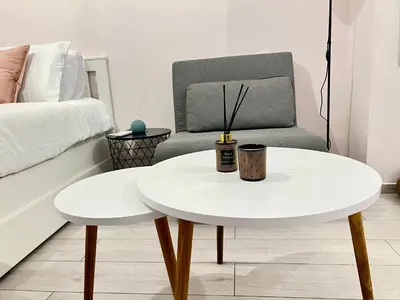 a white coffee table and a chair in a bedroom at Alice Museum Retreat in Athens