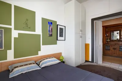 a bedroom with a bed with green and white walls at Acropolis Masterpiece Two-Story Neoclassical Mansion in Athens