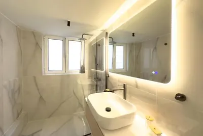a white bathroom with a sink and a mirror at Maya's Apt near Athens center in Athens