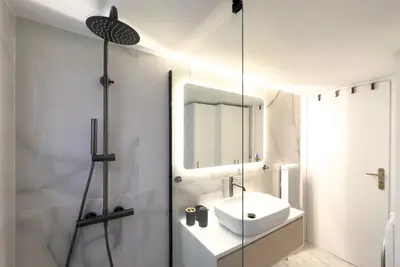 a white bathroom with a sink and a mirror at Maya's Apt near Athens center in Athens