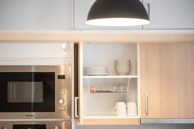 a kitchen with a microwave and some plates and bowls at Maya's Apt near Athens center in Athens