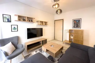 a living room with a couch and a tv at Maya's Apt near Athens center in Athens