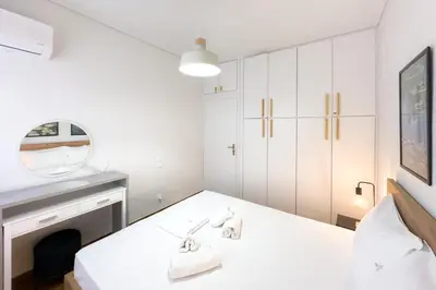 a white room with a table and a mirror at Maya's Apt near Athens center in Athens