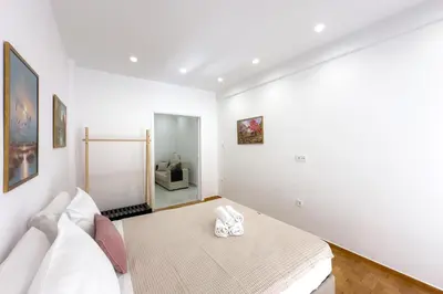 a white room with a bed and a mirror at Eclectic Moonstone apartment in Athens in Athens