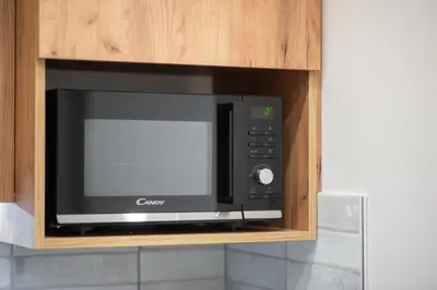 a microwave oven in a cabinet in a kitchen at Eclectic Moonstone apartment in Athens in Athens