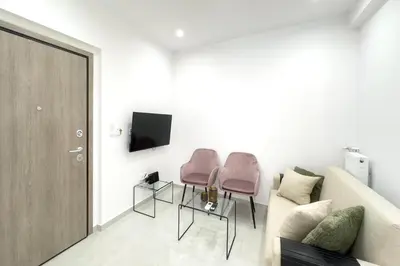 a living room with two pink chairs and a couch at Eclectic Moonstone apartment in Athens in Athens
