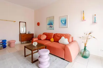 a living room with an orange couch and a table at Athens City Center Gem-Acropolis View-Bright Spacious Flat in Athens