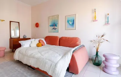 a bedroom with a bed with an orange couch at Athens City Center Gem-Acropolis View-Bright Spacious Flat in Athens