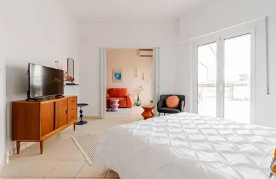 a white bedroom with a large bed and a flat screen tv at Athens City Center Gem-Acropolis View-Bright Spacious Flat in Athens