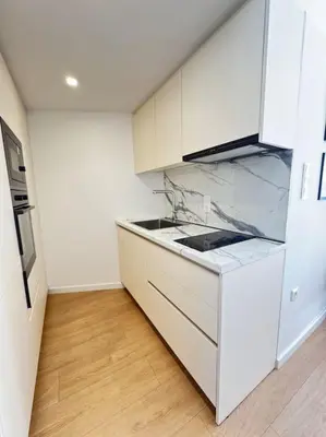 a kitchen with white cabinets and a marble counter top at Pangrati Muse Loft Athens in Athens