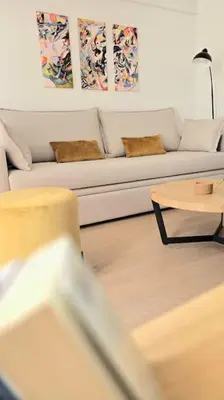 a living room with a white couch and a table at Pangrati Muse Loft Athens in Athens