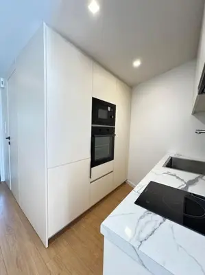 a kitchen with white cabinets and a black oven at Pangrati Muse Loft Athens in Athens