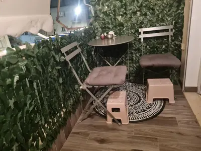 a couple of chairs and a table in front of a green wall at akinitapanou in Athens