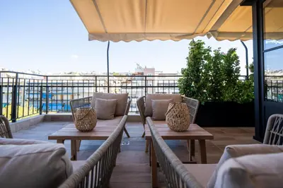 a patio with two tables and chairs on a balcony at Luxury Petralona Penthouse - Sleeps 7 -Near Metro in Athens