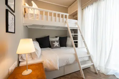 a bedroom with a bunk bed with a ladder at Luxury Petralona Penthouse - Sleeps 7 -Near Metro in Athens