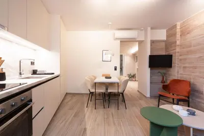 a kitchen and living room with a table and chairs at Cozy & Chic Stay with Patio Near Metro Station in Athens