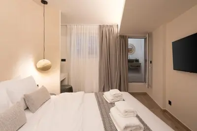 a bedroom with a white bed with towels on it at Cozy & Chic Stay with Patio Near Metro Station in Athens