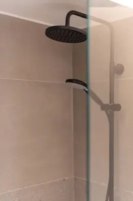 a shower with two lights on a glass door at Cozy & Chic Stay with Patio Near Metro Station in Athens