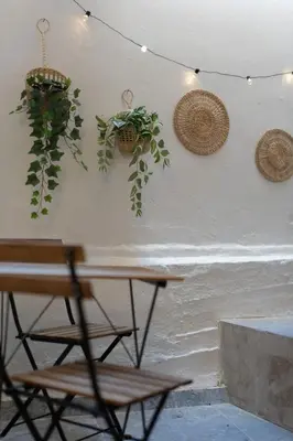 a table and chairs next to a wall with plants at Cozy & Chic Stay with Patio Near Metro Station in Athens