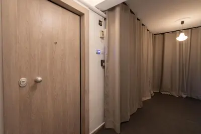 a row of doors in a hallway with curtains at Cozy & Chic Stay with Patio Near Metro Station in Athens