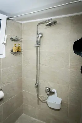 a shower with a shower head in a bathroom at Chic One-Bedroom retreat near Panathenaic Stadium in Athens