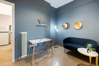 a blue living room with a blue couch and a table at Chic One-Bedroom retreat near Panathenaic Stadium in Athens