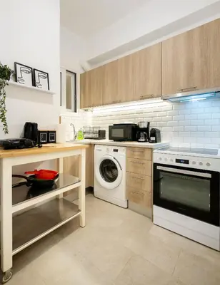 a kitchen with a washing machine and a washer at Chic One-Bedroom retreat near Panathenaic Stadium in Athens