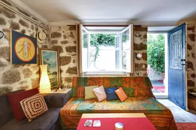 a living room with a couch and a window at Charming Stone house, 500 meters to Acropolis in Athens